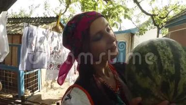 一位身穿乌克兰民俗服装的年轻女子手里拿着一个西瓜，手里拿着一个在农村院子里洗衣服的西瓜